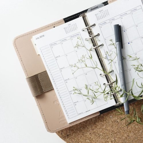 grey and black pen on calendar book